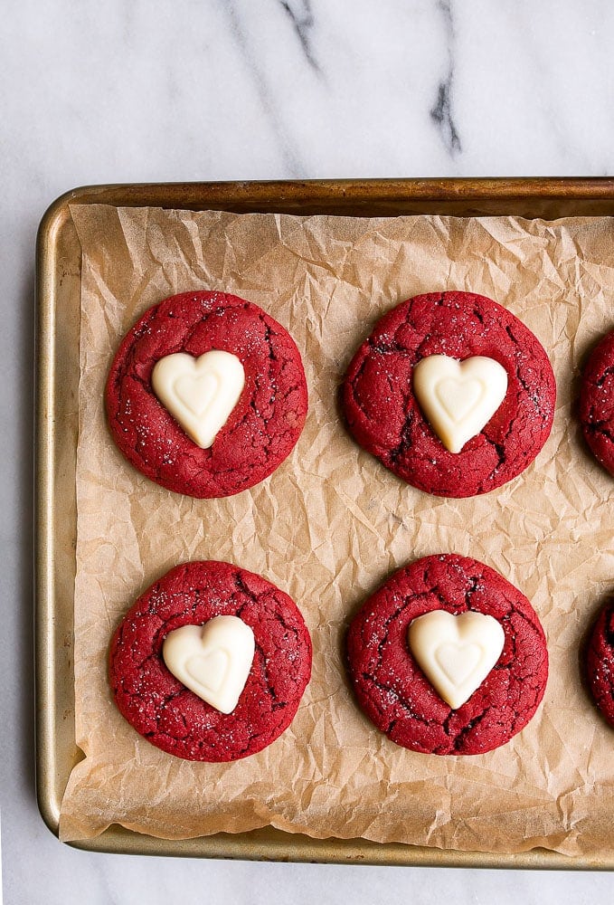 Red velvet cookies with a white chocolate heart in the center.