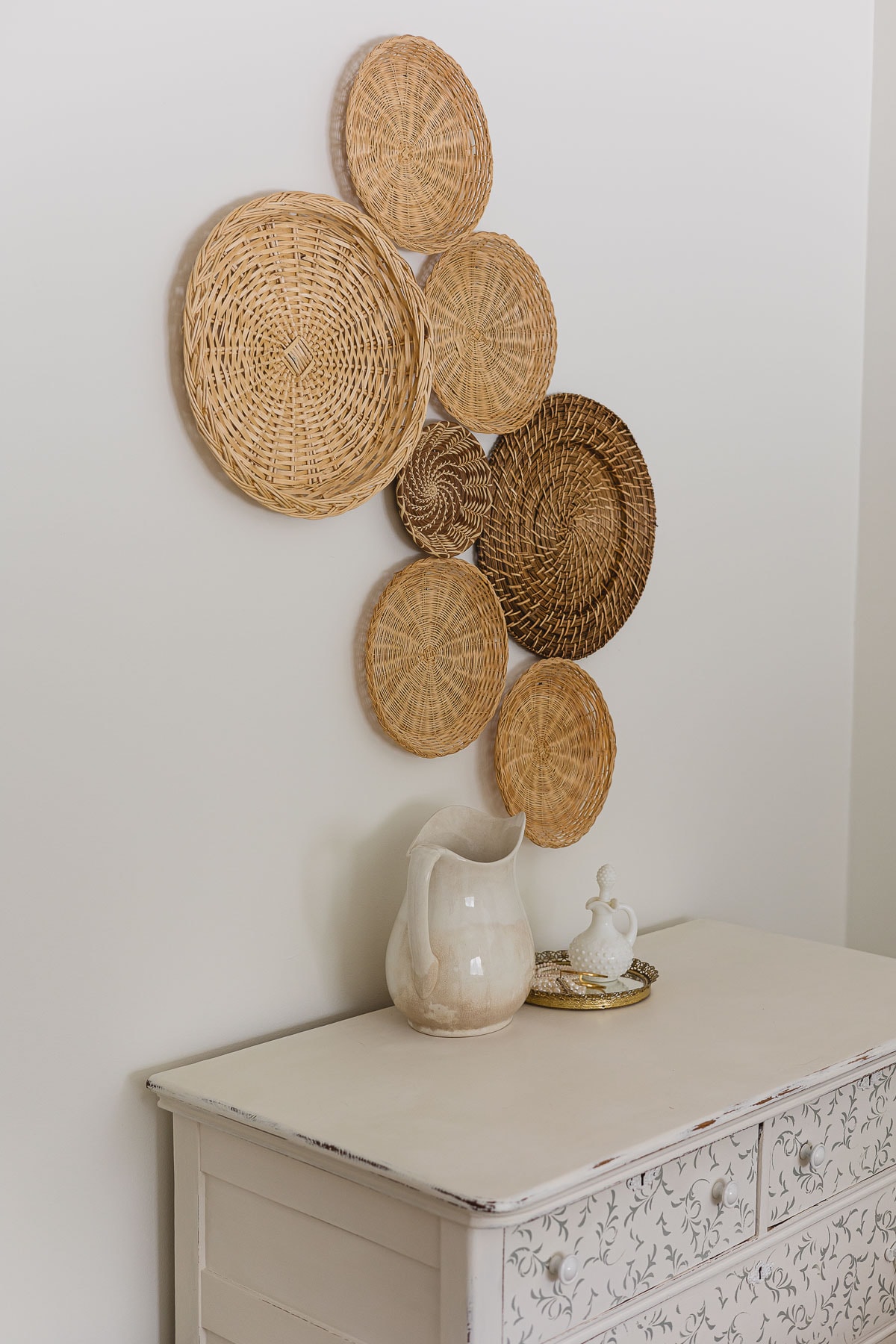 A dresser with an ironstone pitcher and basket galley wall.