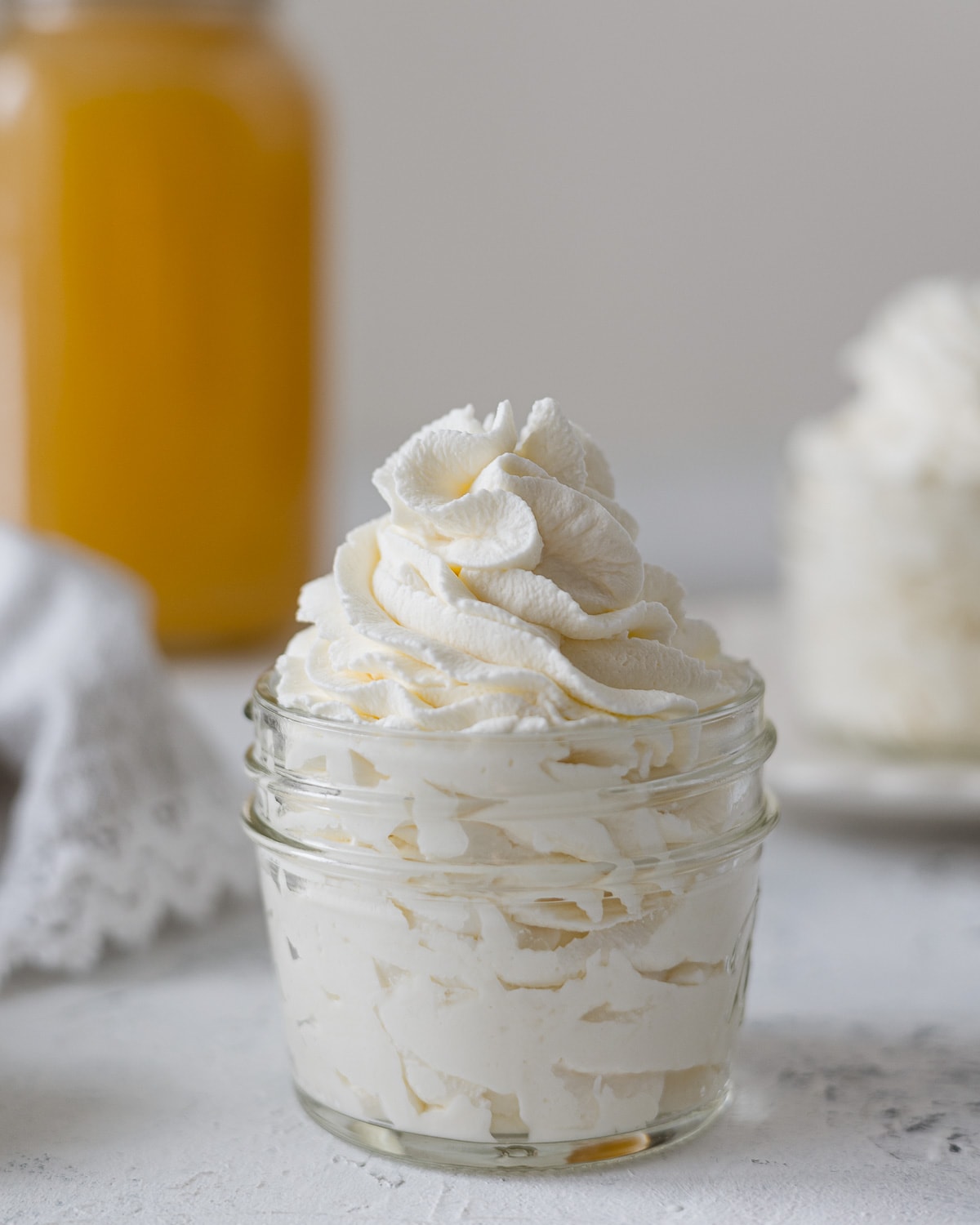 A jar filled with swirls of piped honey whipped cream.