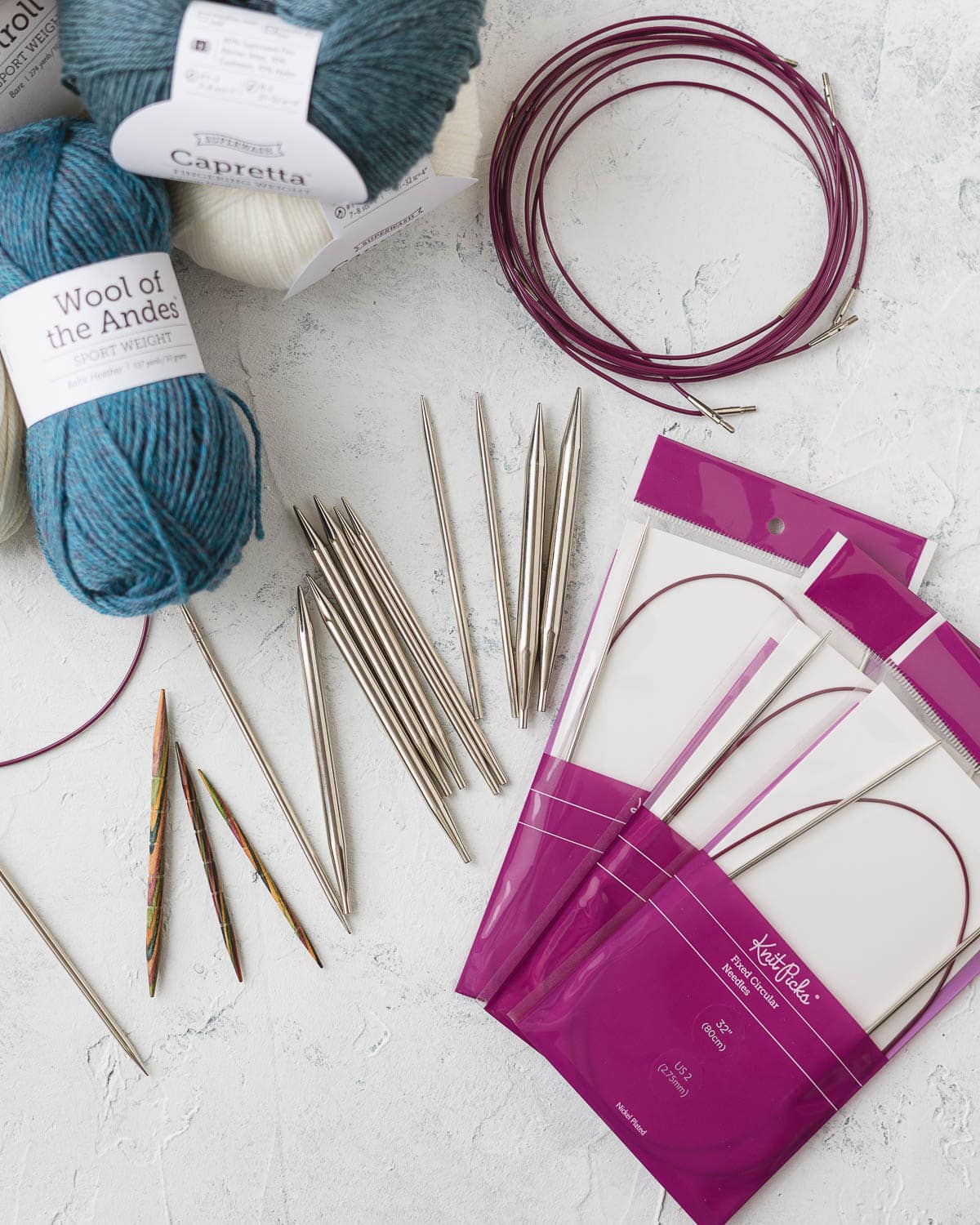 Nickel plated interchangeable knitting needle set, cables, additional fixed needles, and yarn.