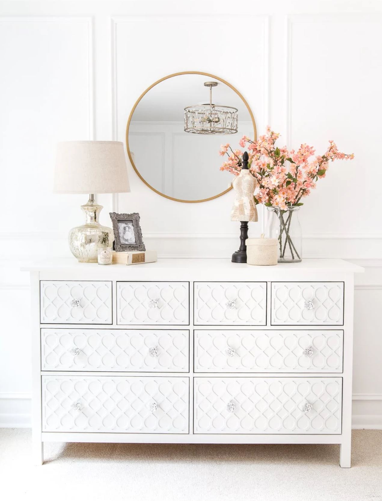 A white IKEA dresser with overlays and white rose knobs.