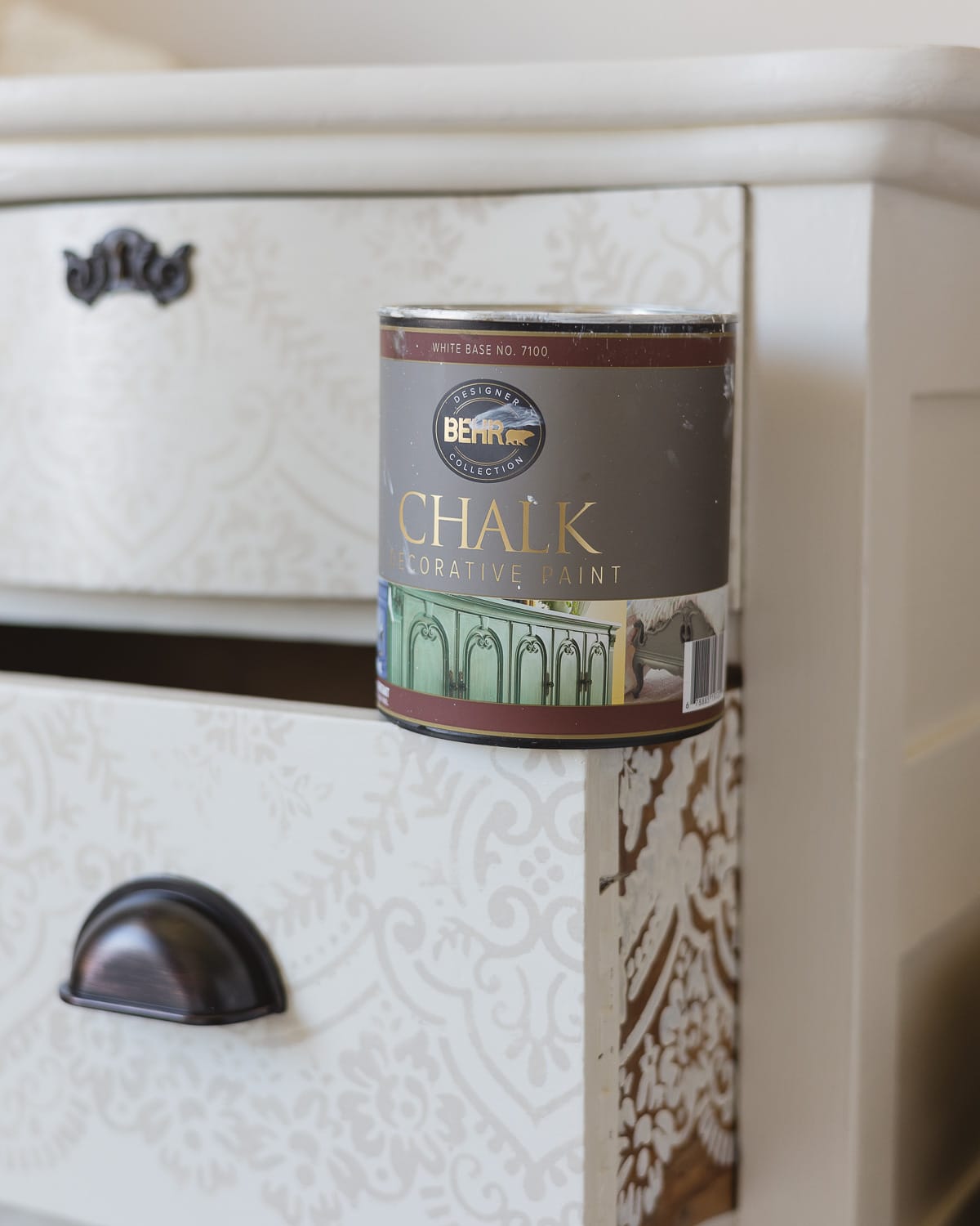 A can of Behr Decorative Chalk Paint resting on the open drawer of a dresser.