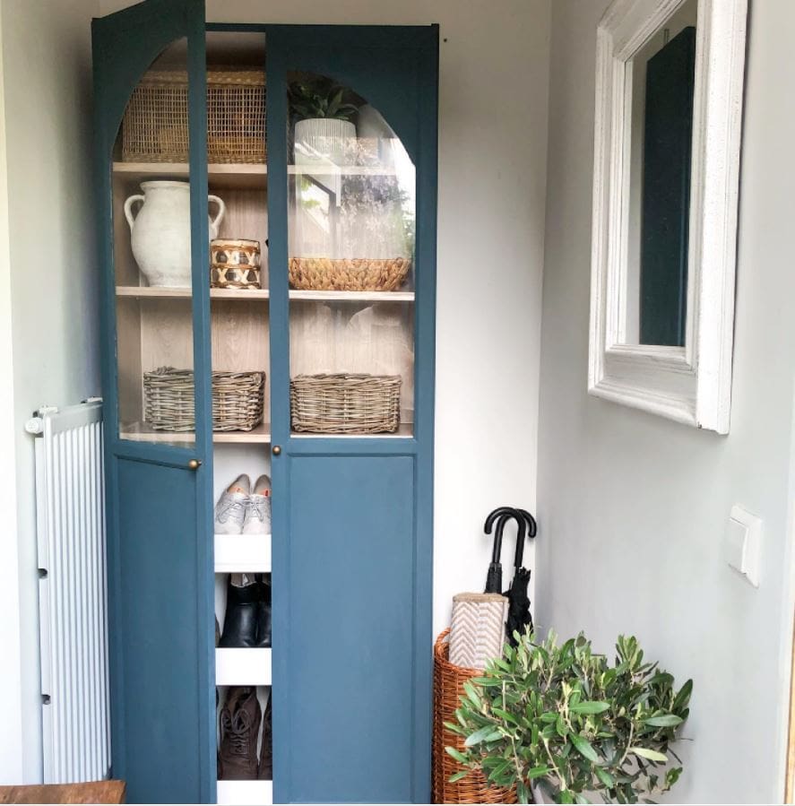 A blue Billy Bookcase with doors and added arch shape in the doors.