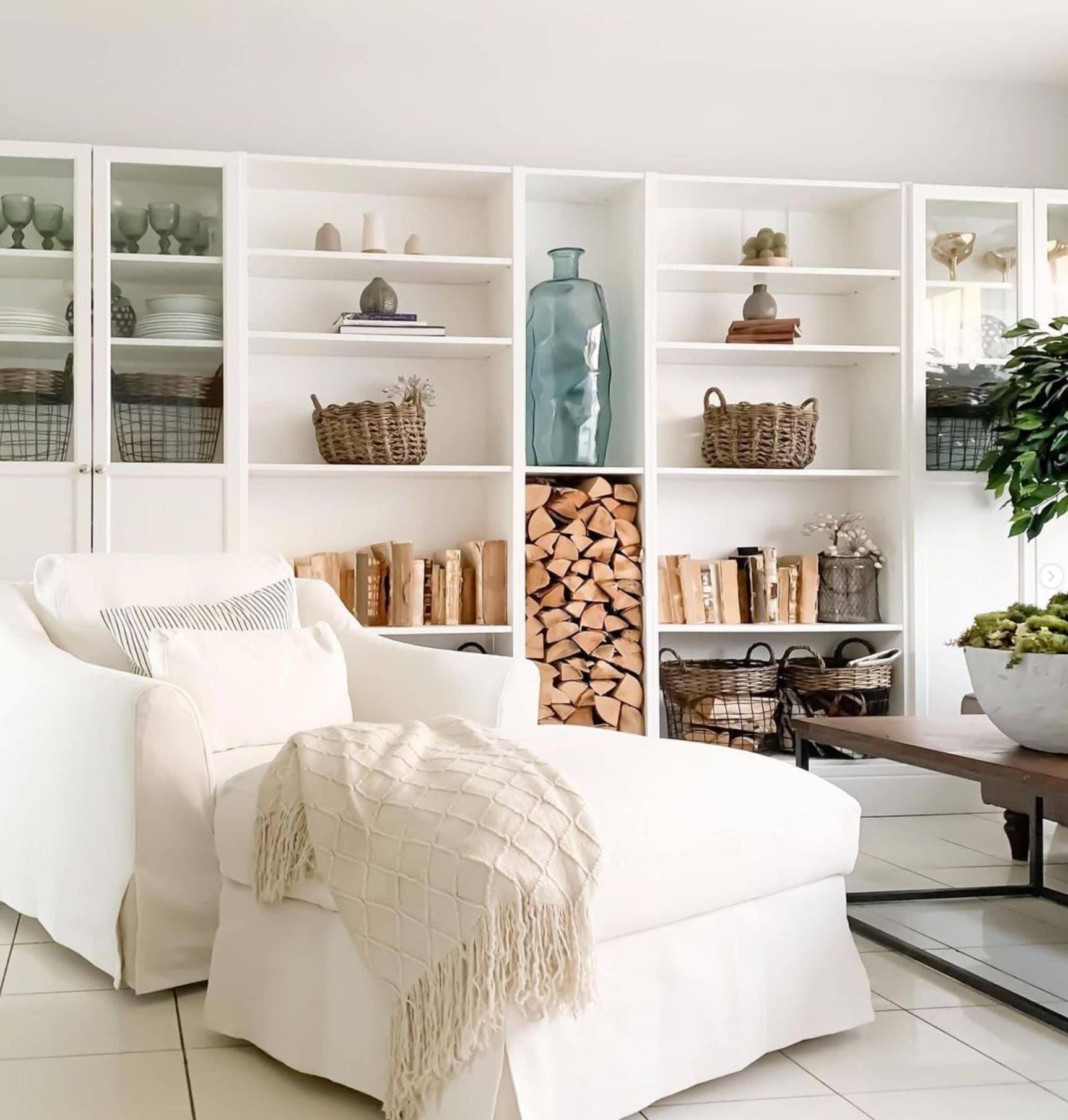 An oversized white armchair with ottoman and Billy Bookcase built-ins.