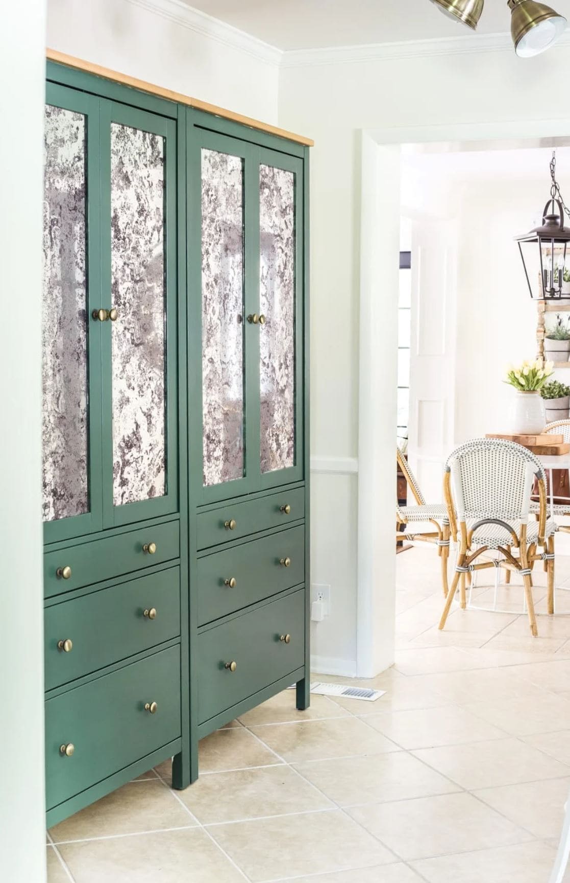 Two green HEMNES cabinets used as pantry storage with gold knobs and antique mirroring in the doors.