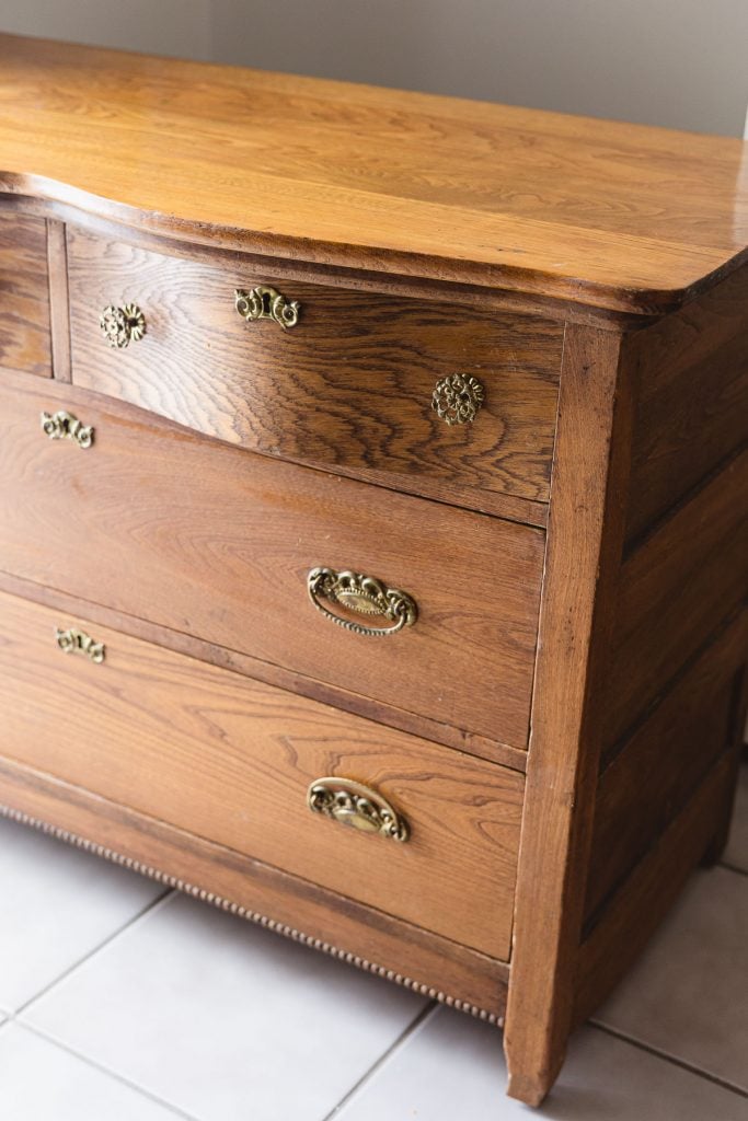 An old wood dresser with vintage brass hardware.