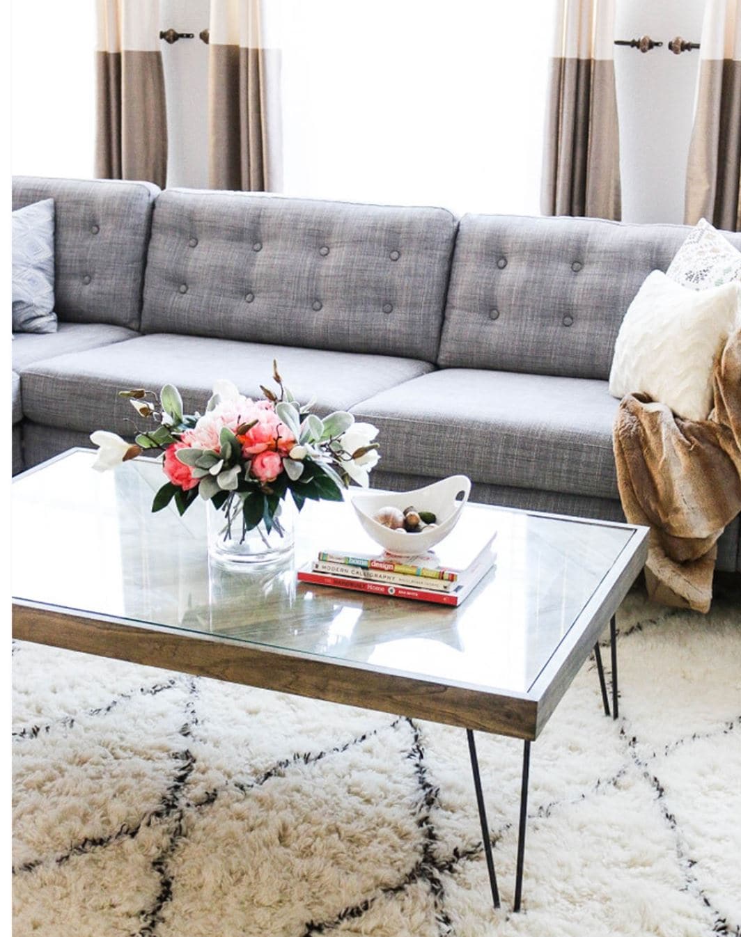 A gray IKEA couch with added tufting on the cushions.