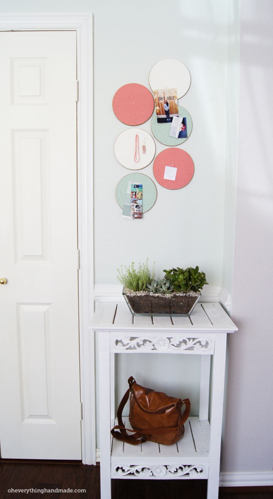 Six painted corkboard organizers hanging over an entryway table in an entryway.