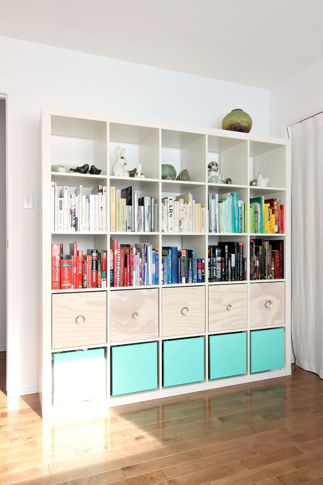 IKEA cube storage with baskets, doors, and books.