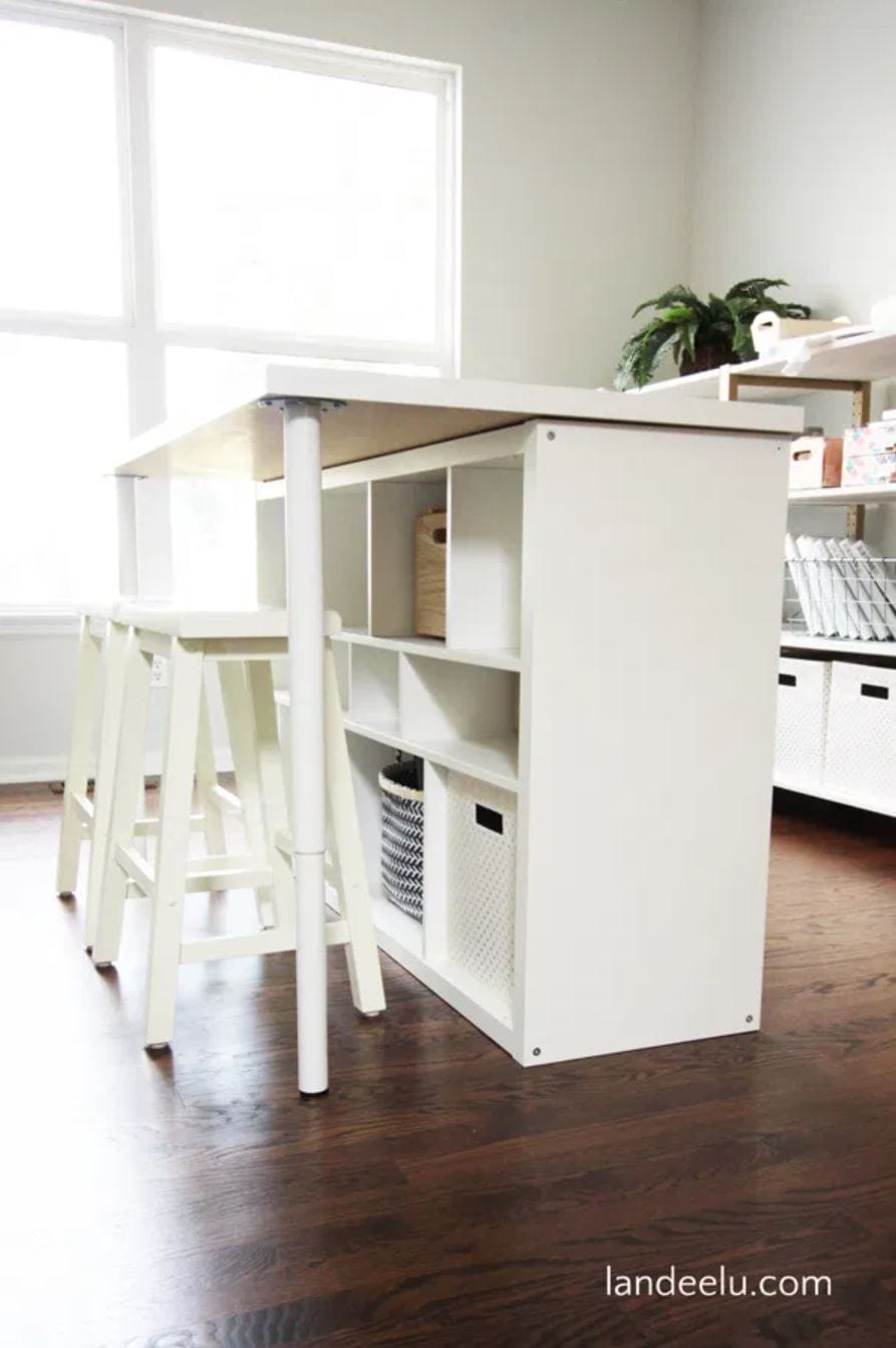 A white DIY craft desk with two white stools.