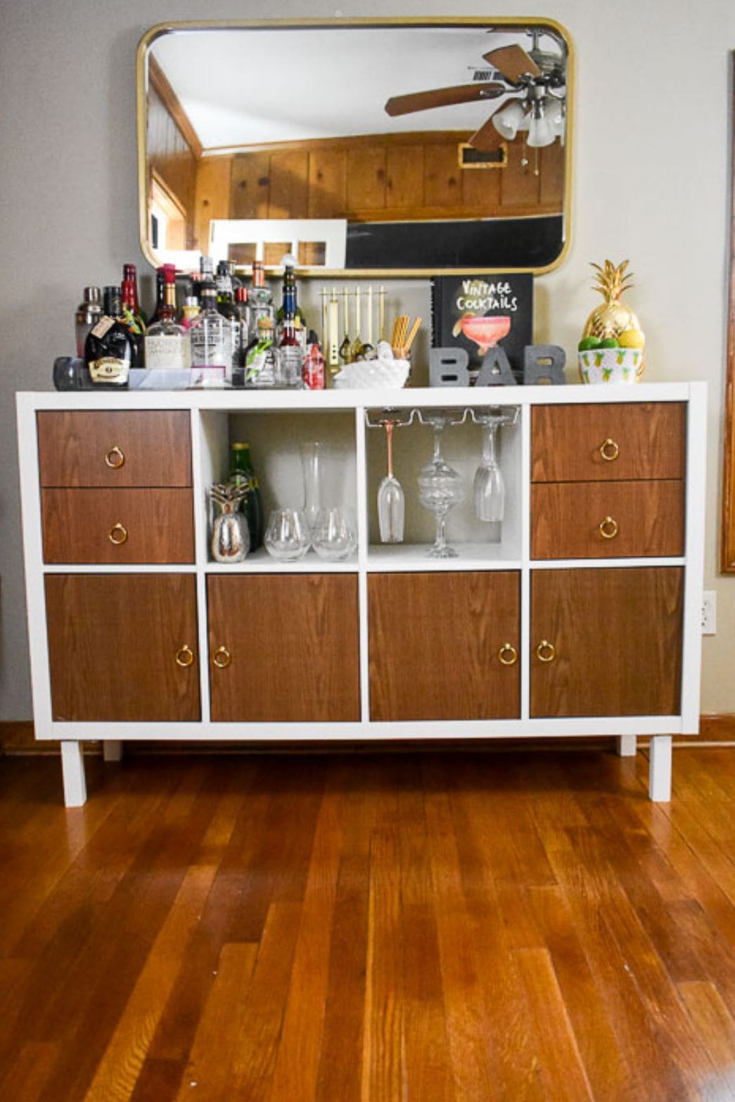 IKEA Kallax home bar with legs and faux wood doors.