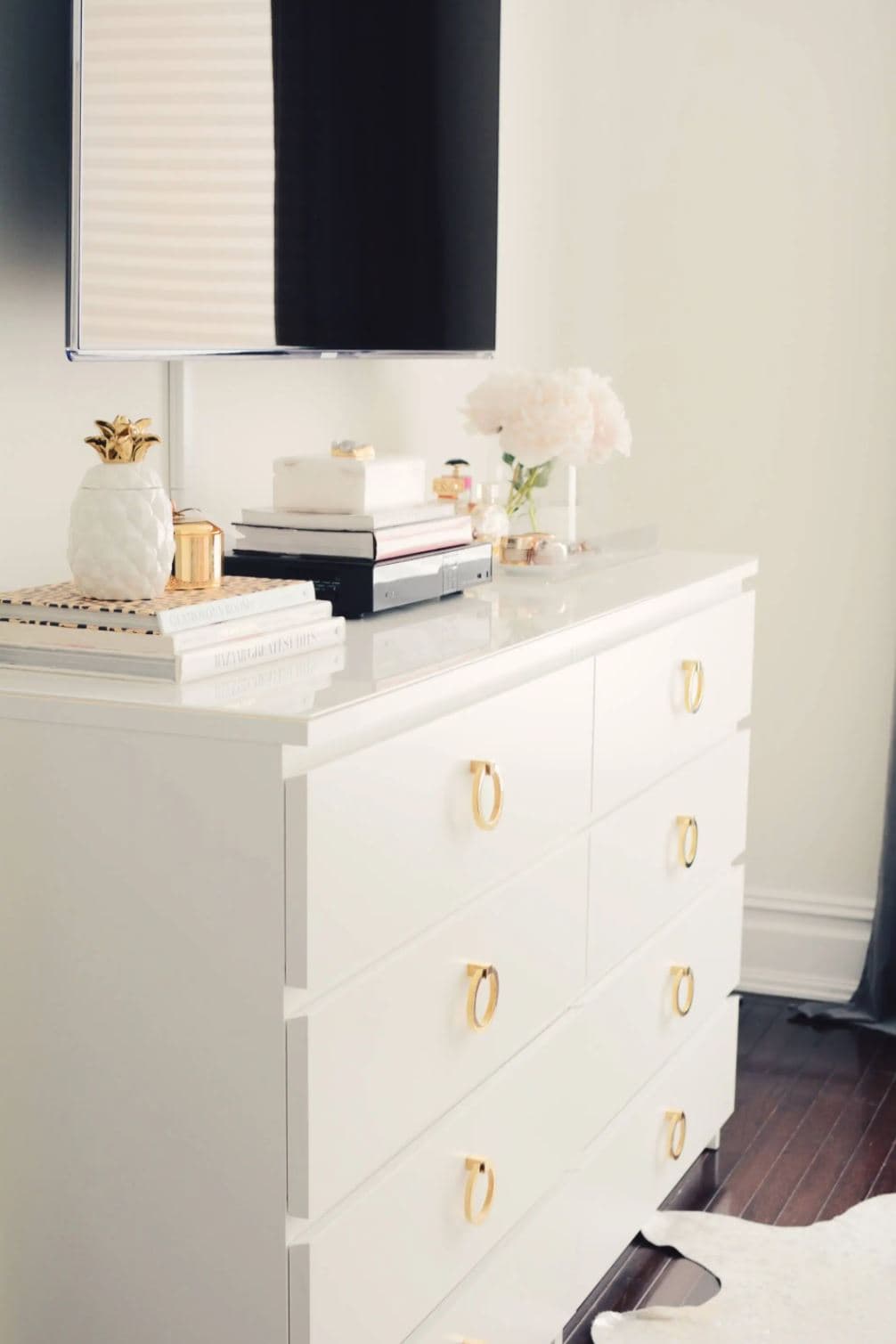 IKEA Malm dresser with brass knobs in a bedroom.