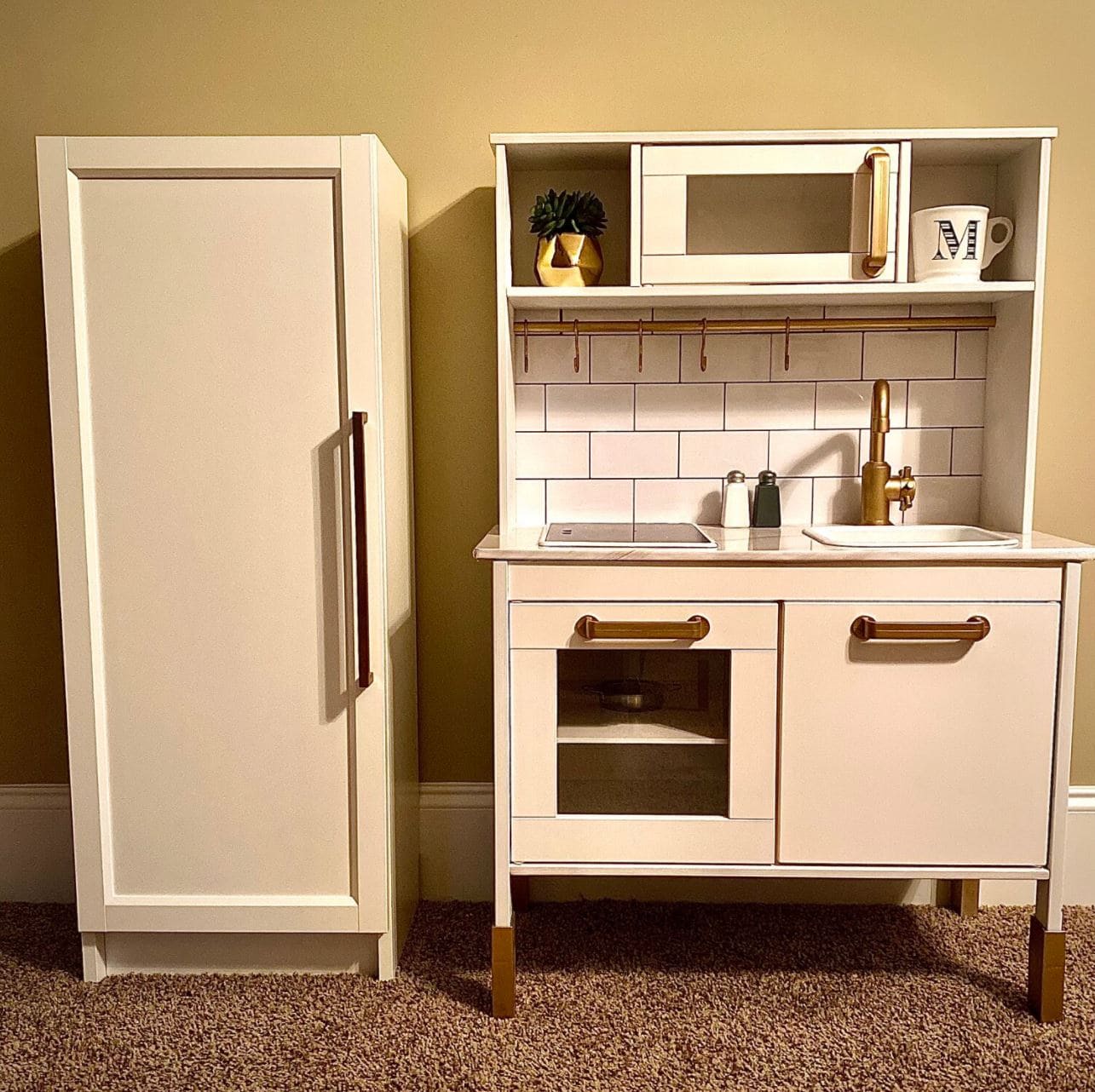 An IKEA play kitchen with a Billy Bookcase fridge.