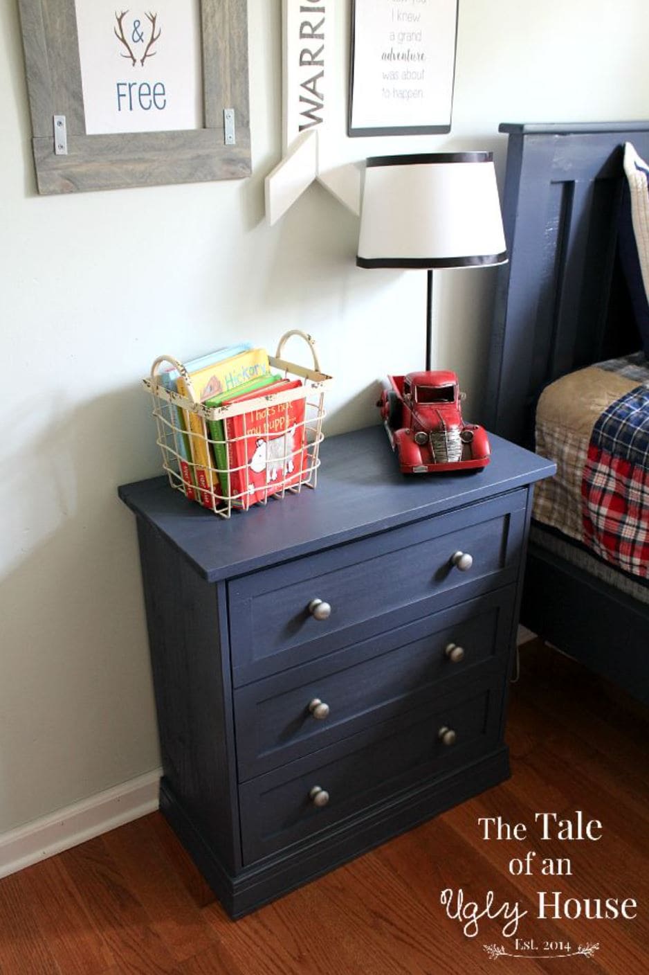 A navy IKEA Rast Nightstand with a vintage red car and basket of books on top.