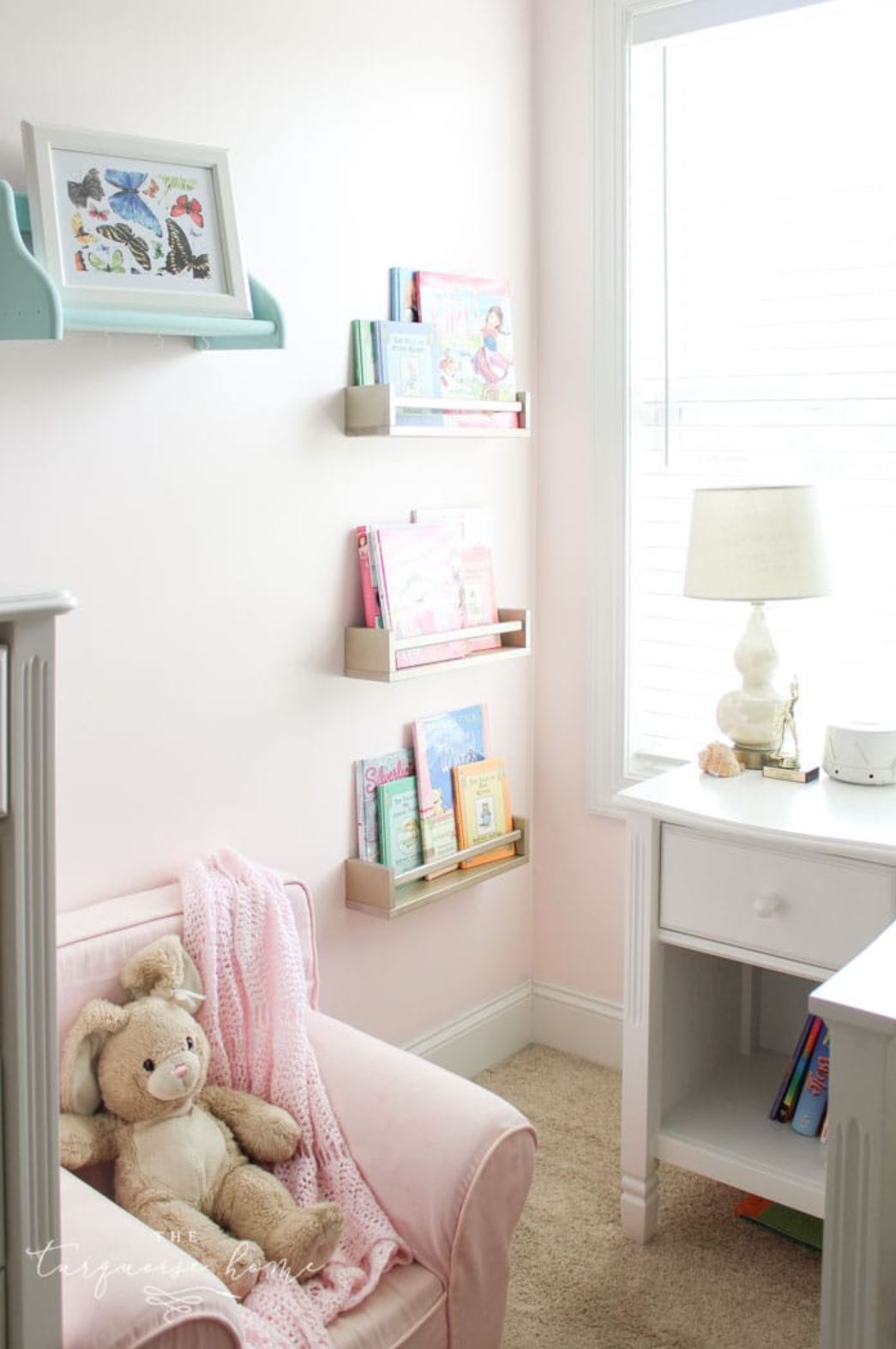 Three IKEA spice racks used as bookshelves in a girl's bedroom.