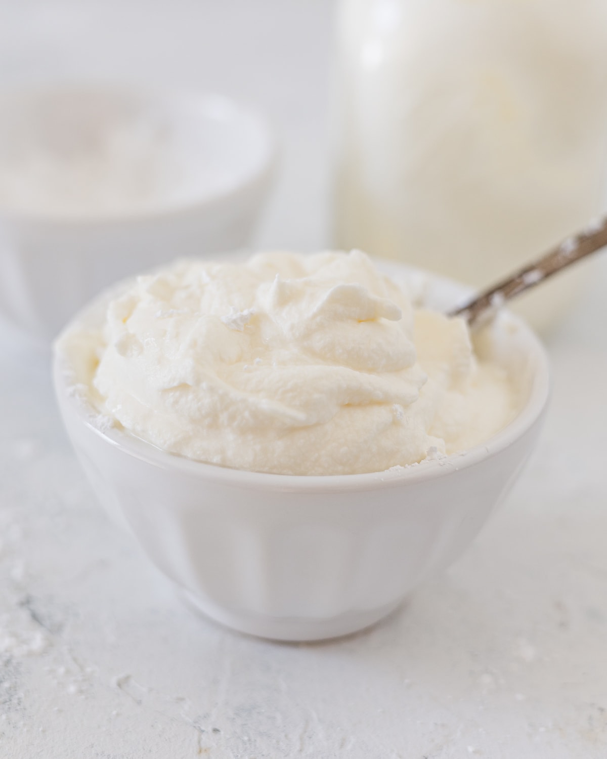 A white bowl filled with fresh whipped cream.