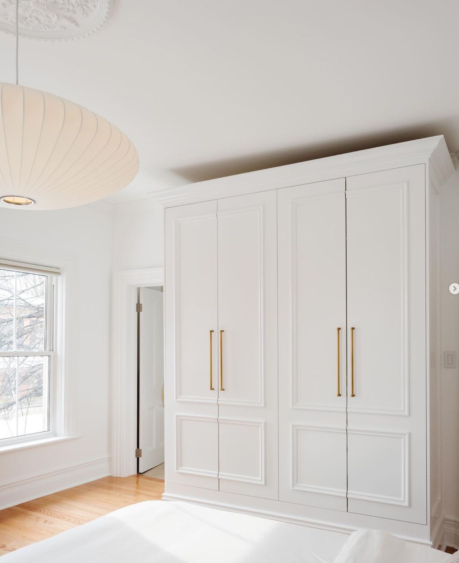 White Pax Wardrobe closet with large brass handles.