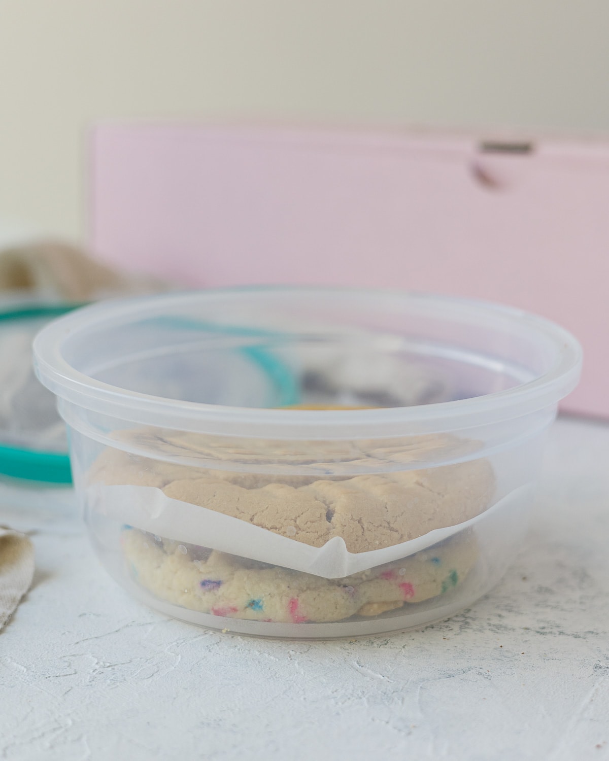 A stack of two cookies in a snapware container ready to freeze.