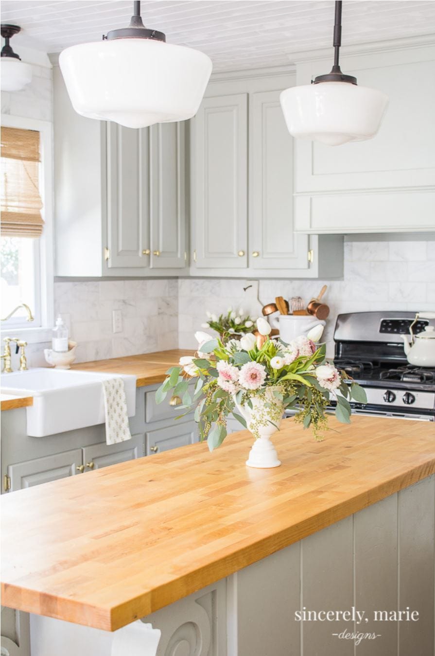 A white shiplap ceiling in a soft green farmhouse kitchen.