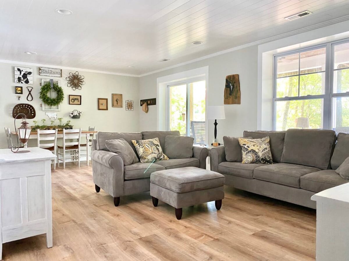 White planked ceilings in a farmhouse living room & dining area.