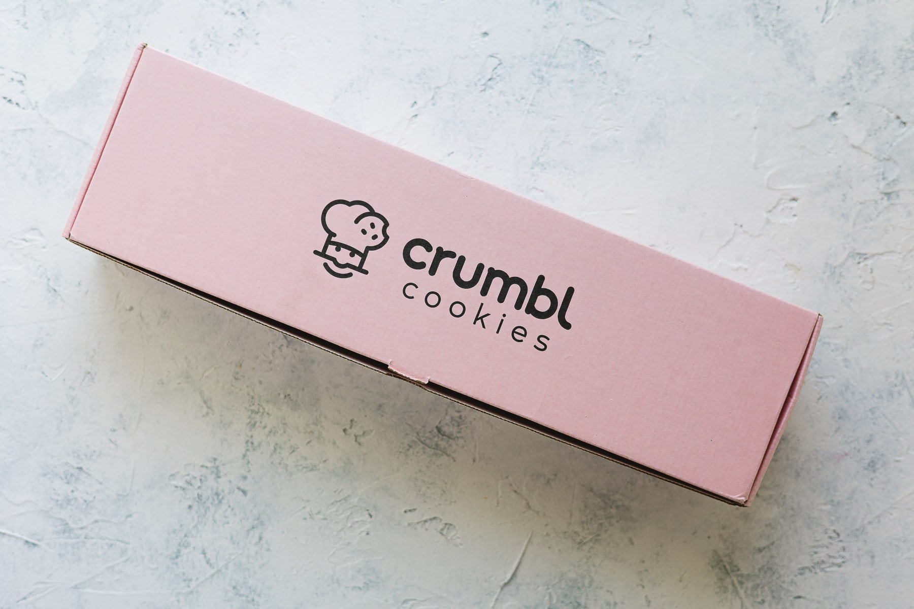 A pink rectangular Crumbl Cookies Shipping box.