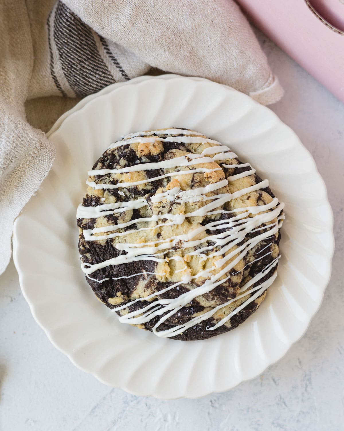 A cookies and cream cookie with a drizzle of white chocolate over the top.