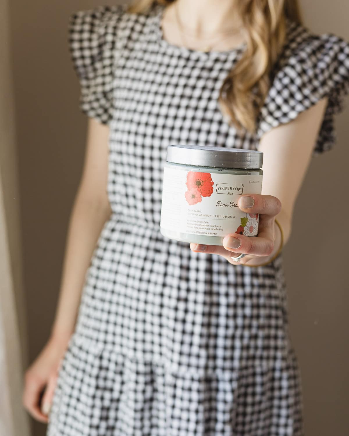 Woman holding a small container of Country Chic Paint.