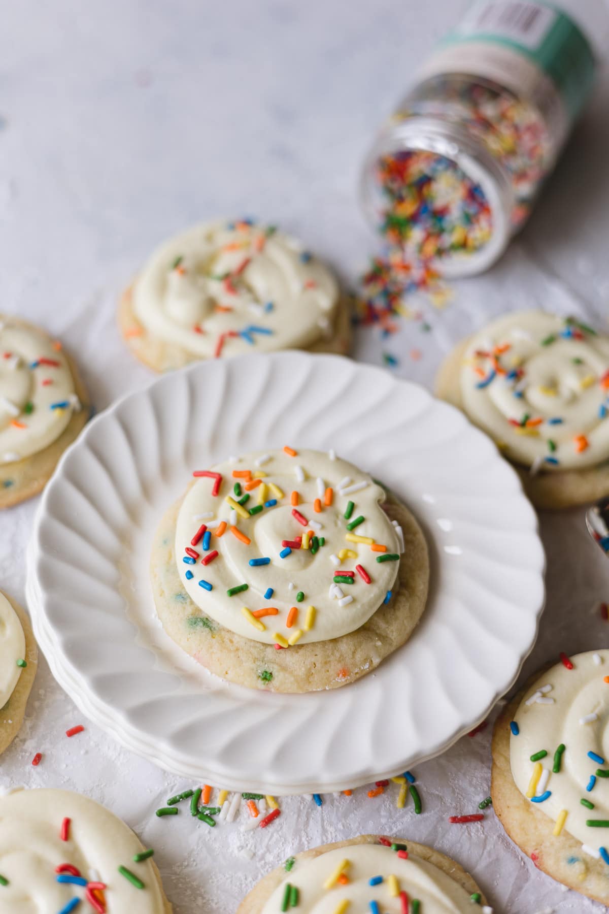 Frosted Funfetti cookies with more sprinkles on top.