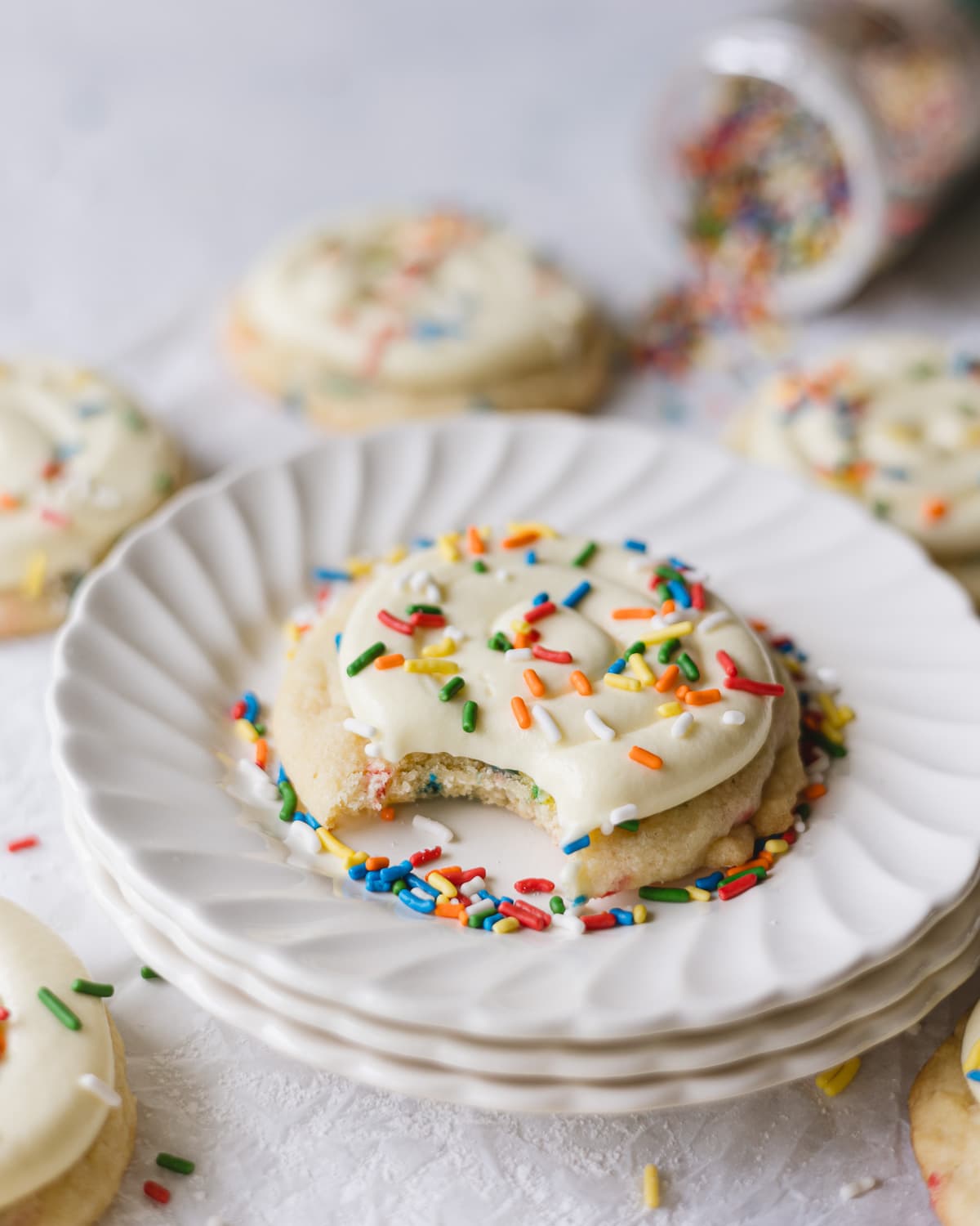 A plated Crumbl Funfetti Copycat cookie on a stack of small plates.