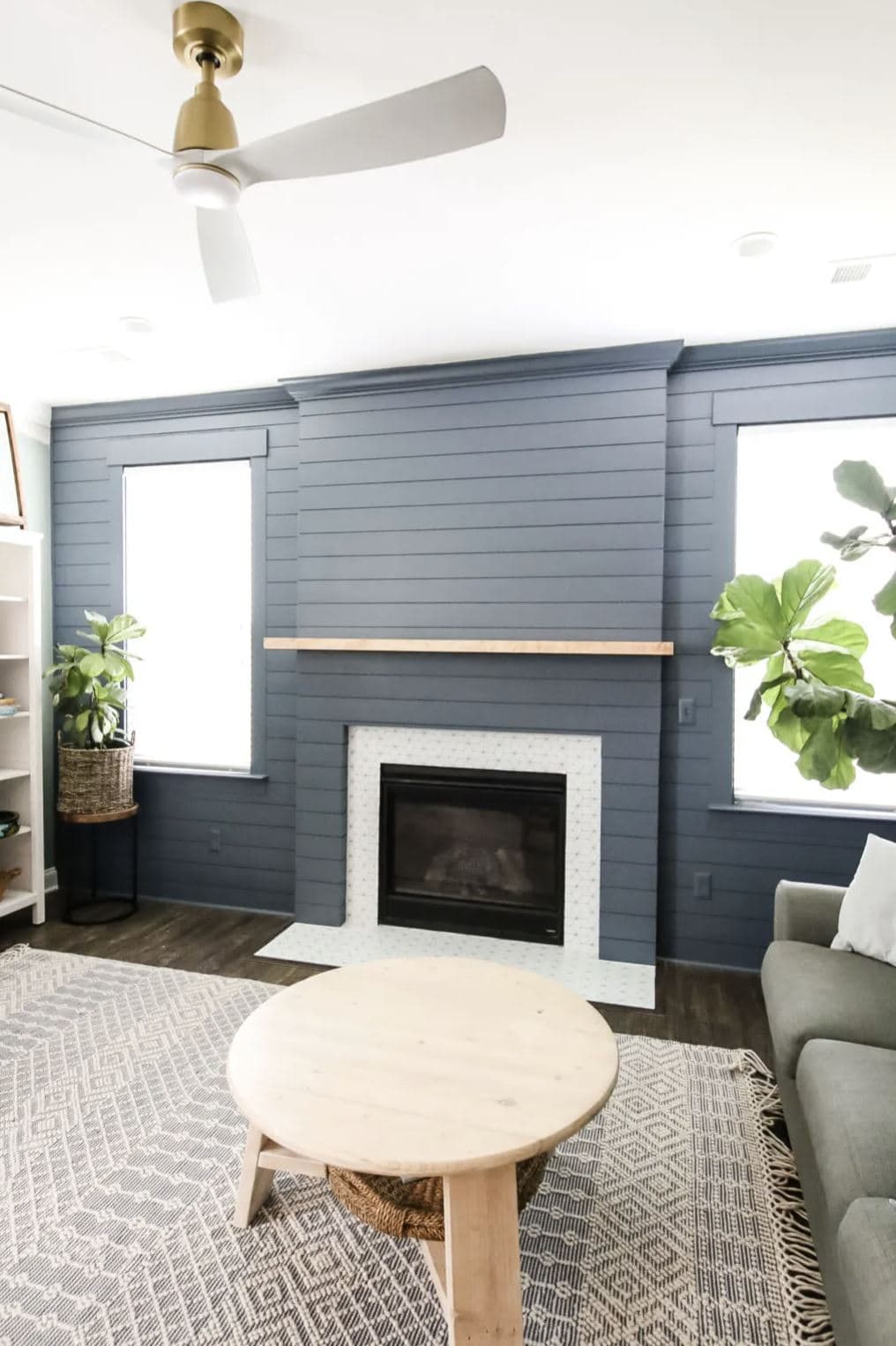 A blue shiplap fireplace and fireplace surround in a casual living room.