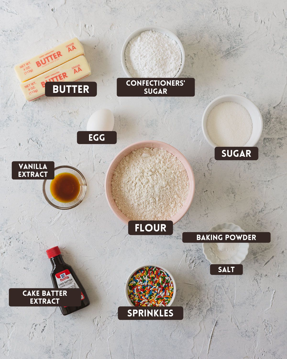 Labelled ingredients for Funfetti Cookies: butter, confectioners' sugar, egg, sugar, vanilla extract, flour, cake batter extract, sprinkles, baking powder, and salt.