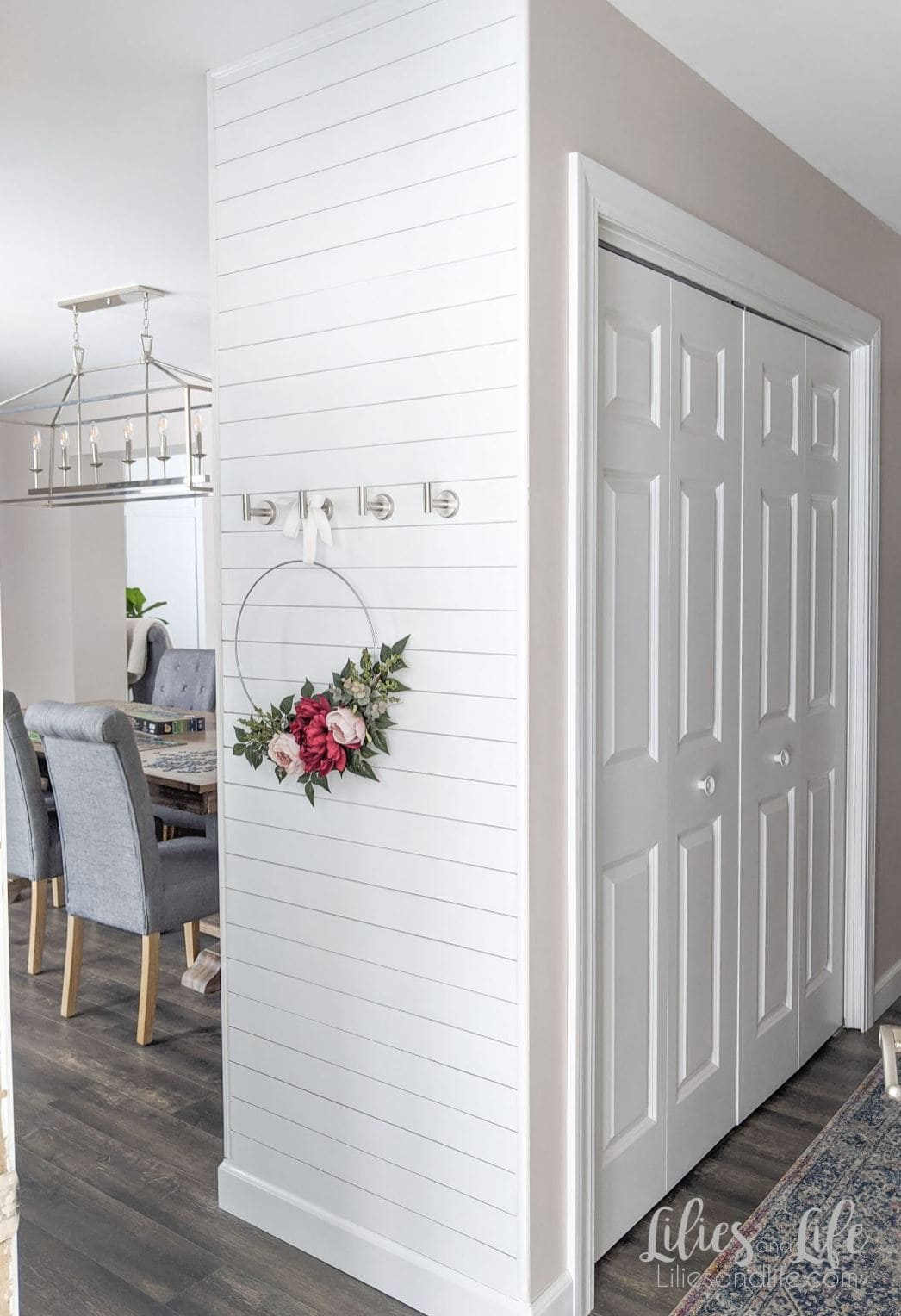 A shiplap accent wall with a floral wreath.