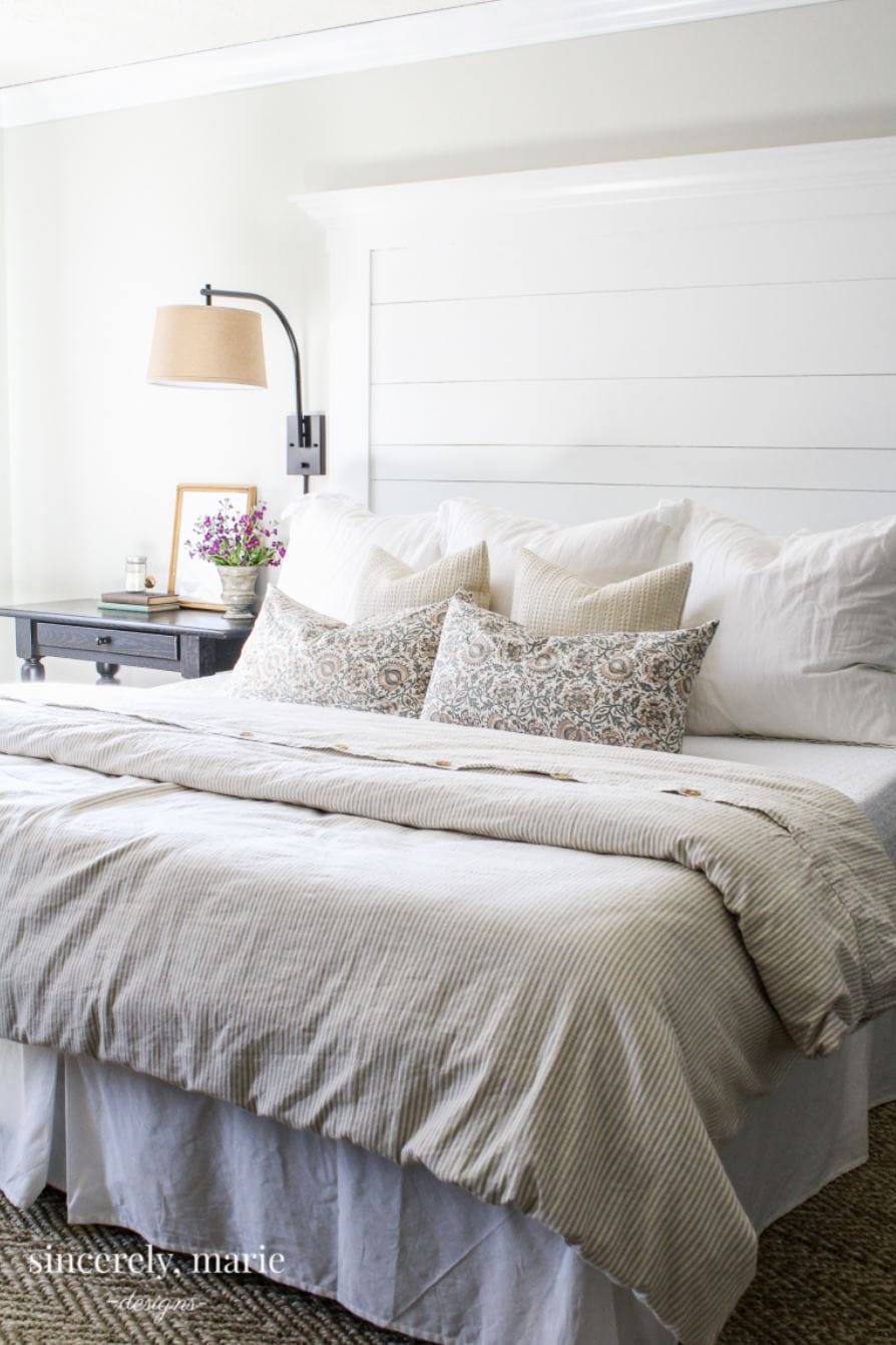 A white shiplap headboard in a farmhouse style bedroom.