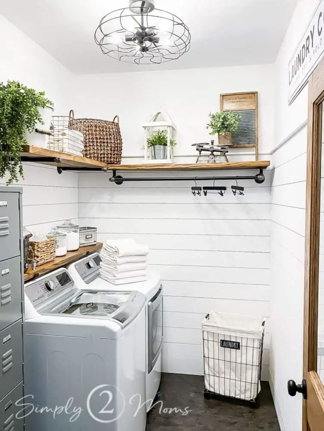 A farmhouse laundry room with shiplap walls, wood shelving, and oil-rubbed bronze hardware.