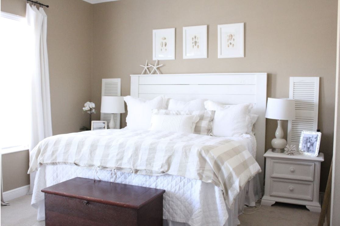 A beach-themed bedroom with a white shiplap headboard.
