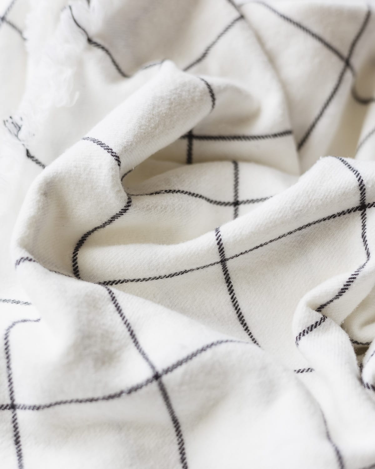 A close-up of white fabric with a black grid design.