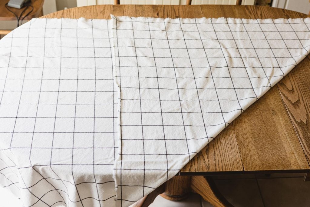 A large piece of fabric on a table with the corner folded up to the top edge.