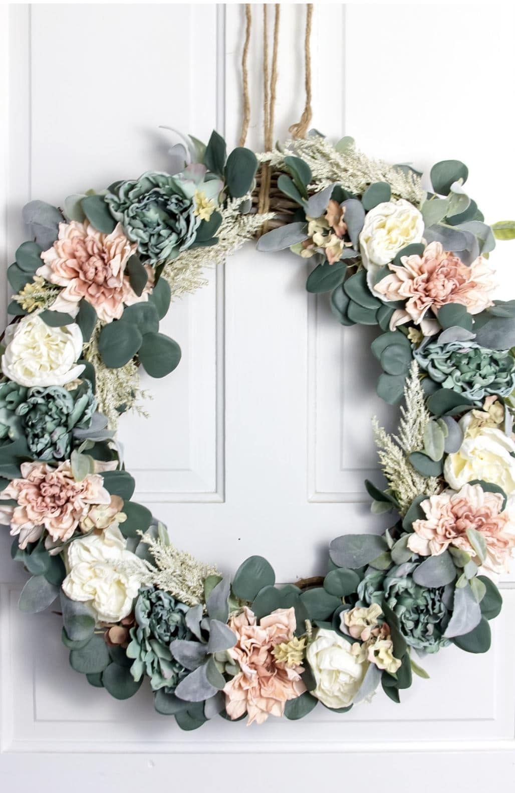 A DIY floral wreath hanging on a door.