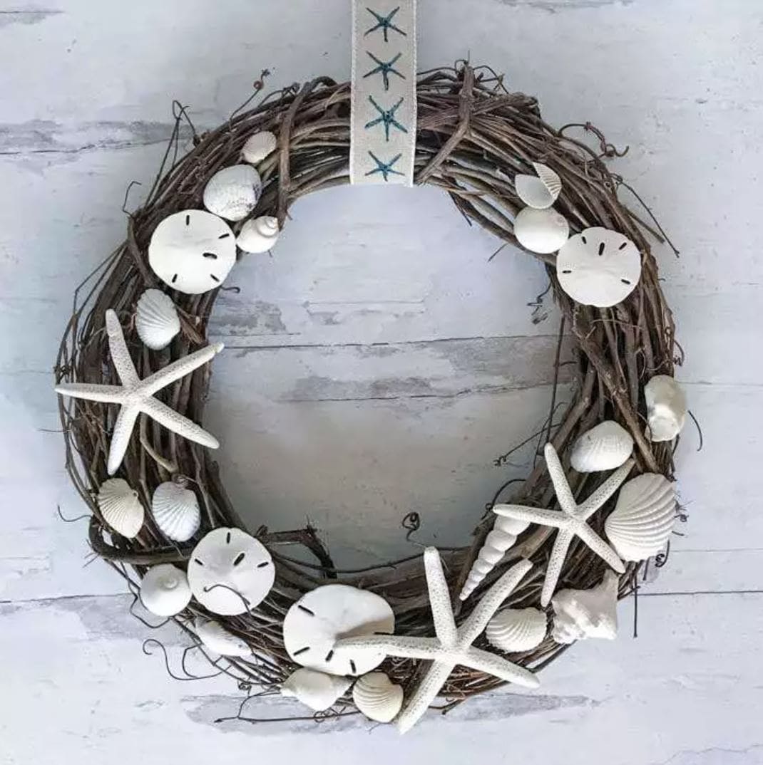A grapevine wreath decorated with seashells.