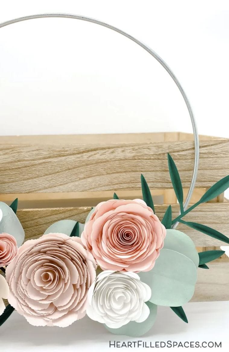 A hoop wreath with handmade paper flowers.