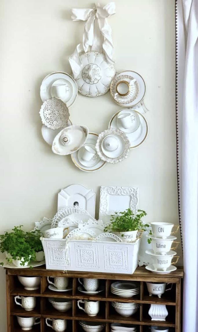 A wreath created from hanging china plates and cups.