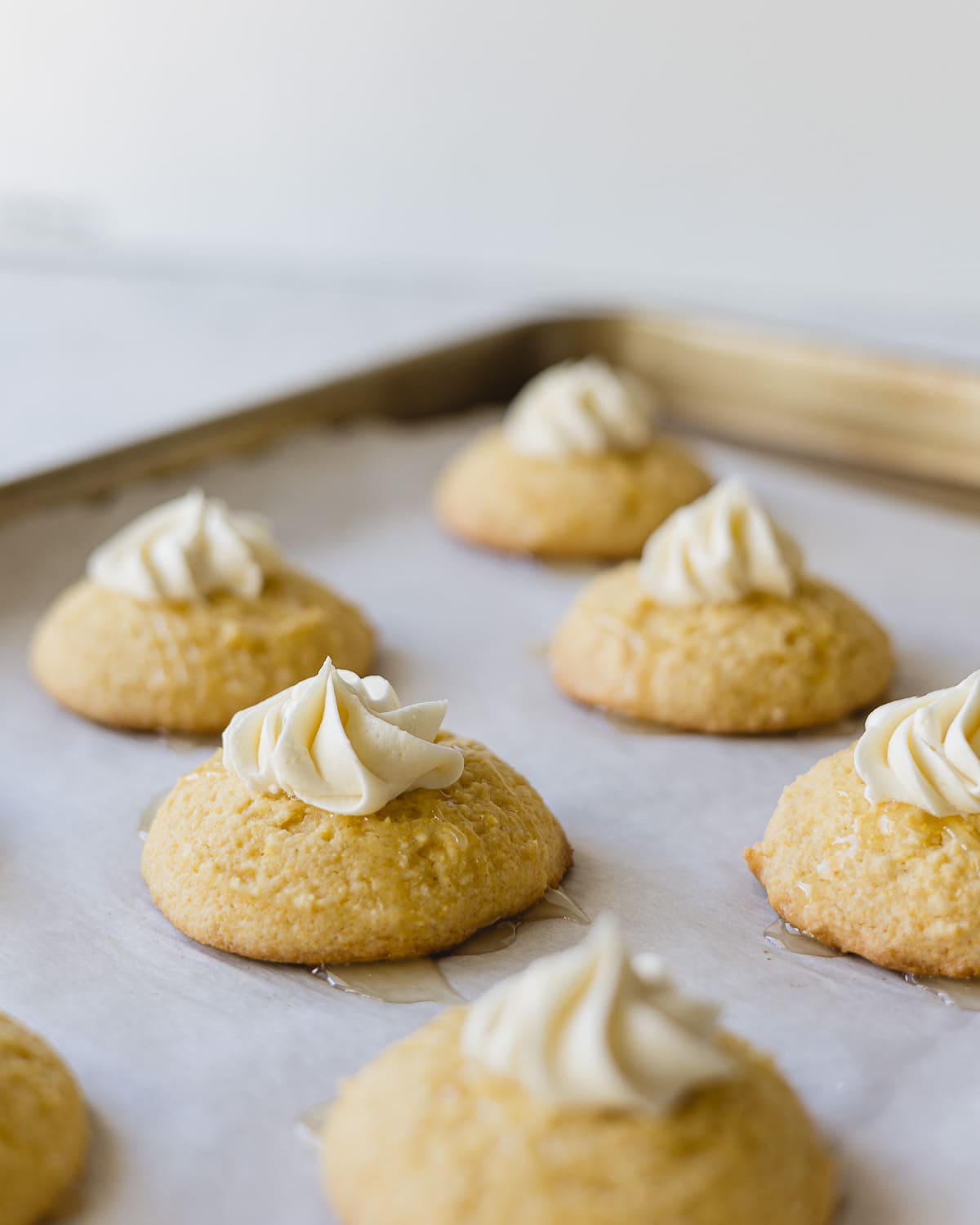 Cornbread Cookies topped with a piped star of honey buttercream and drizzled with honey butter.