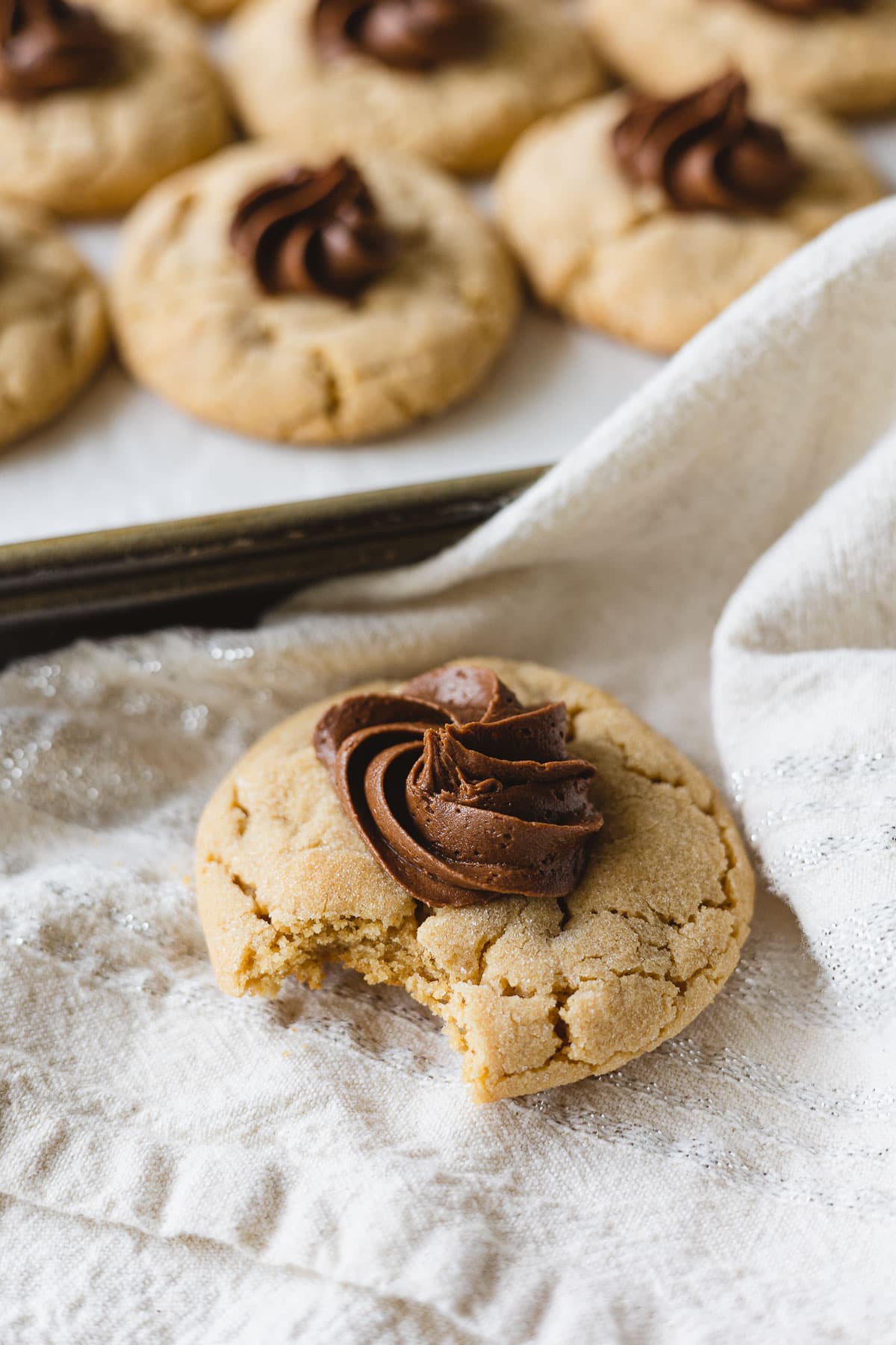 A Crumbl copycat peanut butter blossom cookie with a bite taken out.