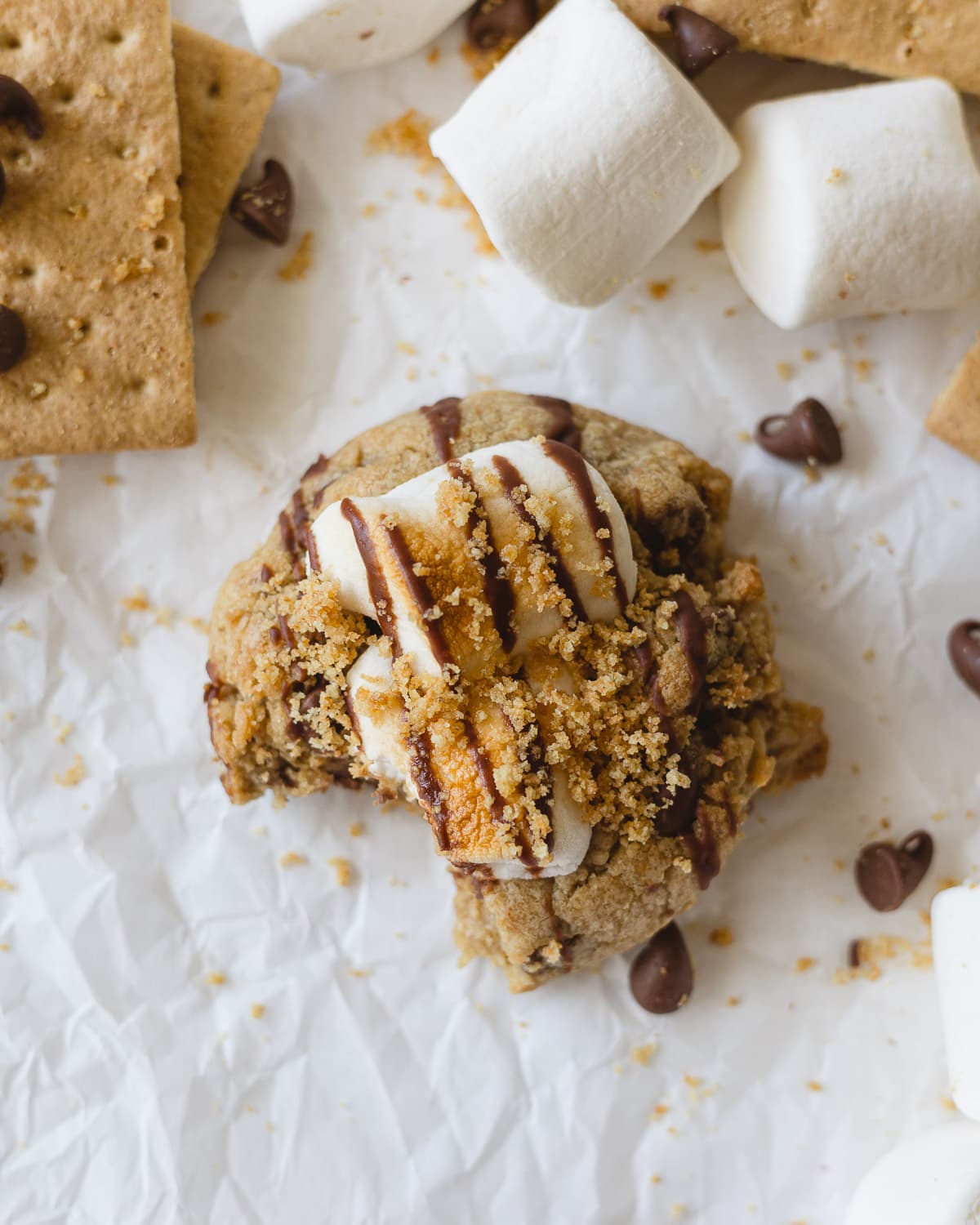 A copycat Crumbl s'mores cookie with a bite out of it.