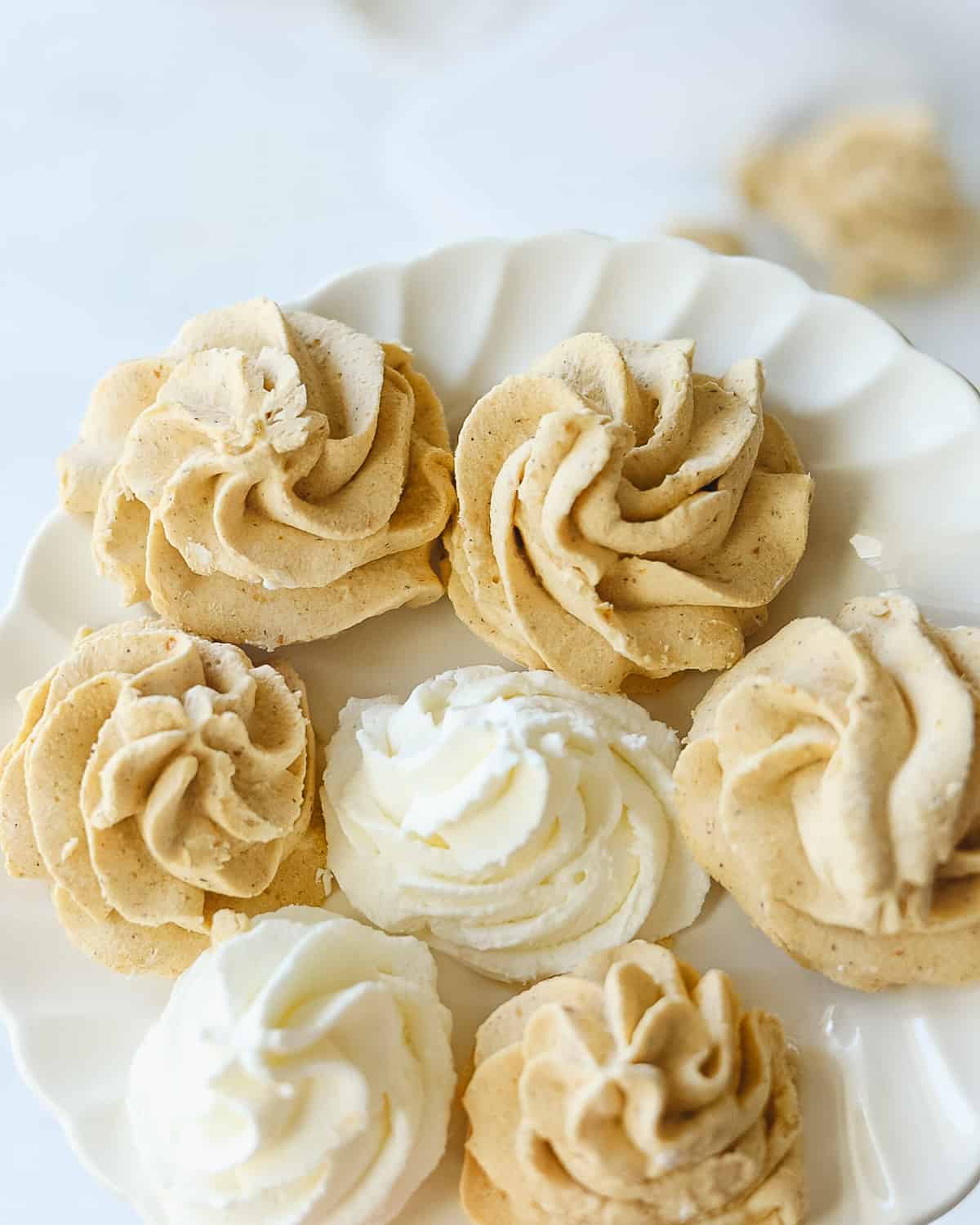 Rosettes of pumpkin and plain whipped cream on a plate.