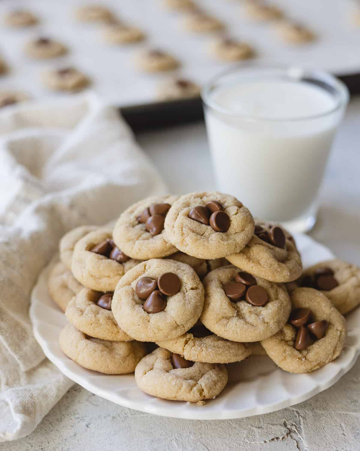 A small plate of mini cookies and a glass of milk.