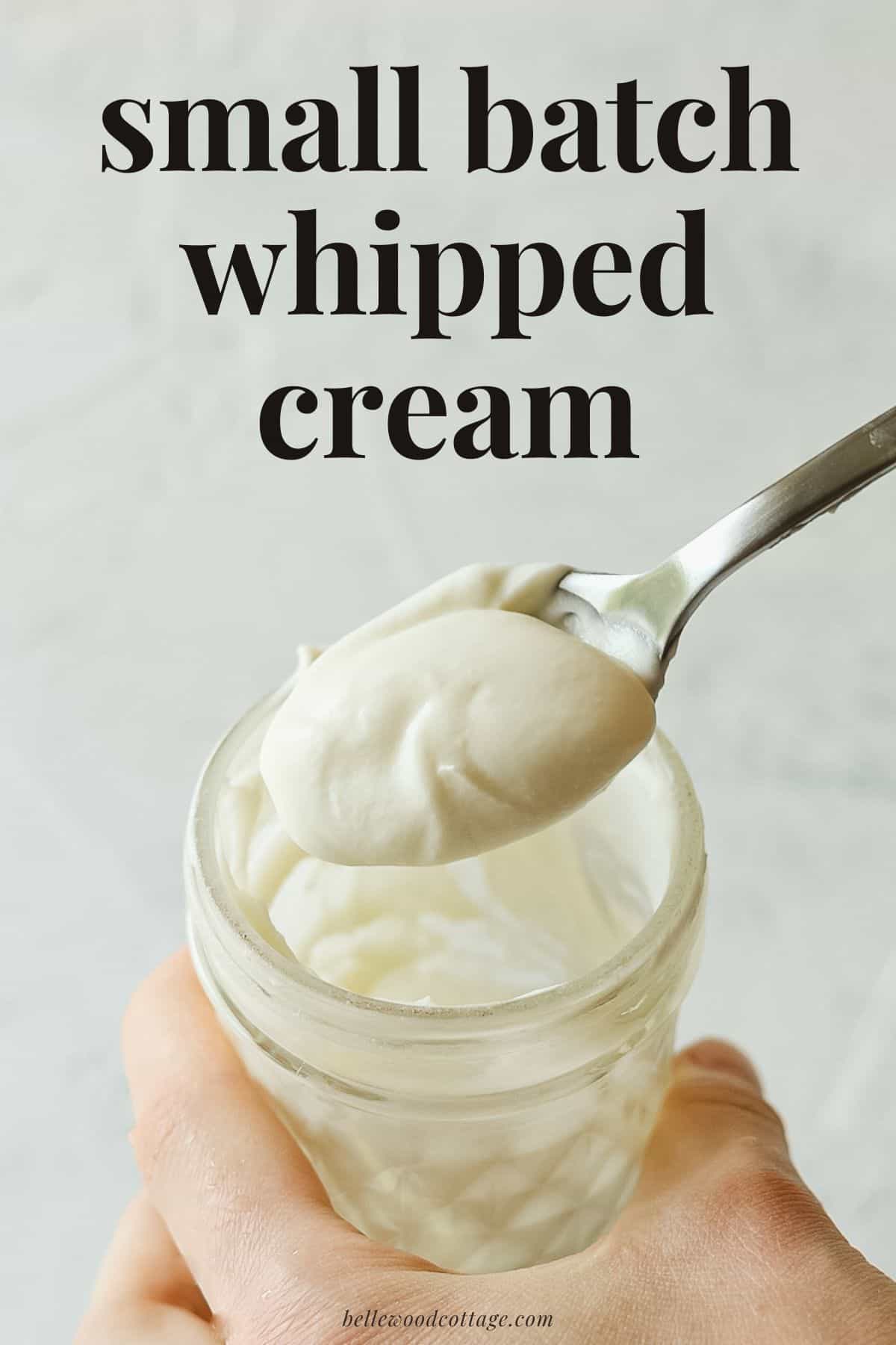 A spoonful of whipped cream from a mason jar with the words, "Small Batch Whipped Cream."