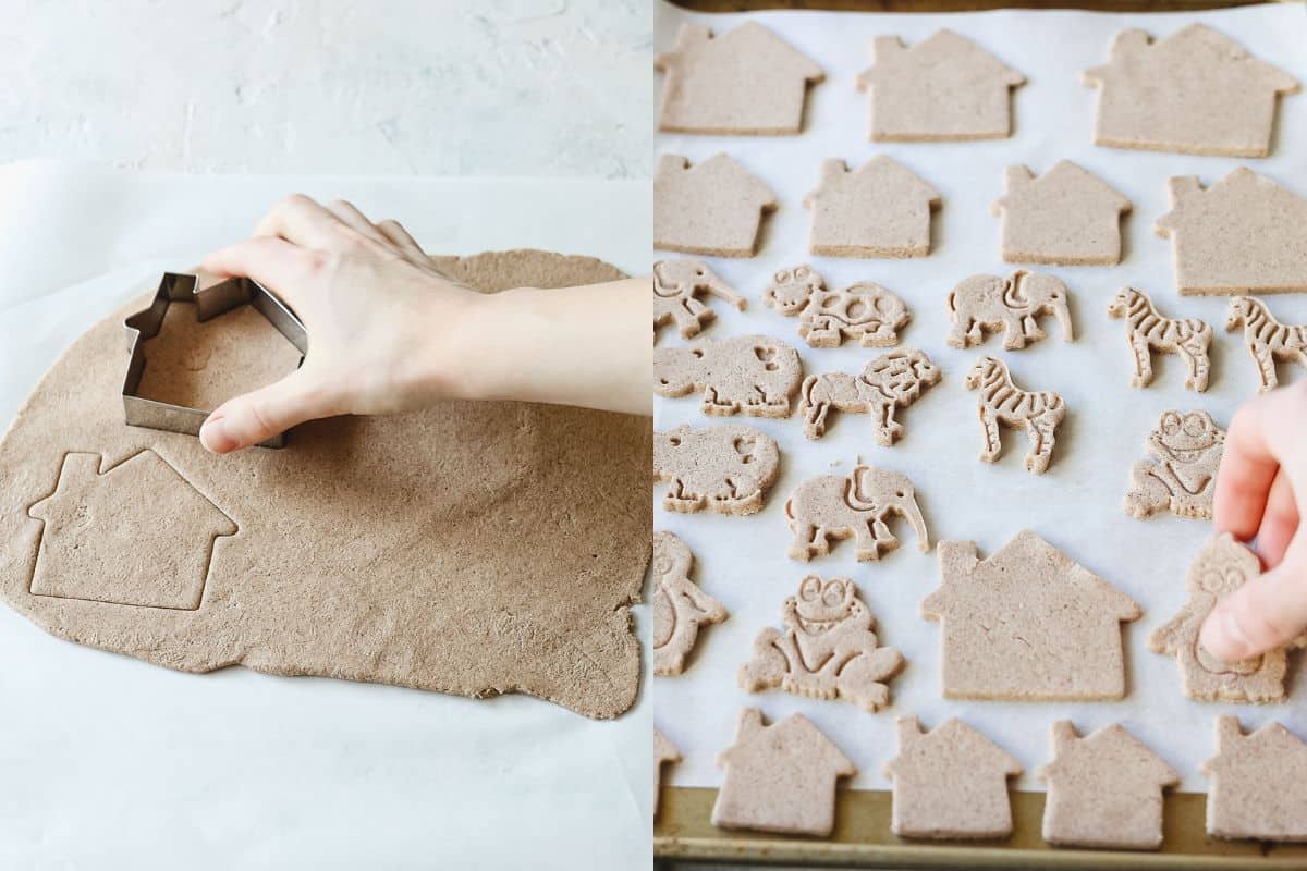 Cutting out house shapes from rolled out salt dough and arranging various shapes on a lined cookie sheet.