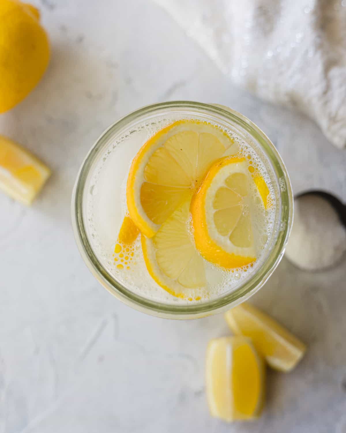 Bright yellow lemon slices on top of a glass of ice-cold lemonade.