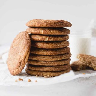 A stack of snickerdoodle cookies with a cookie leaning upright against the stack.